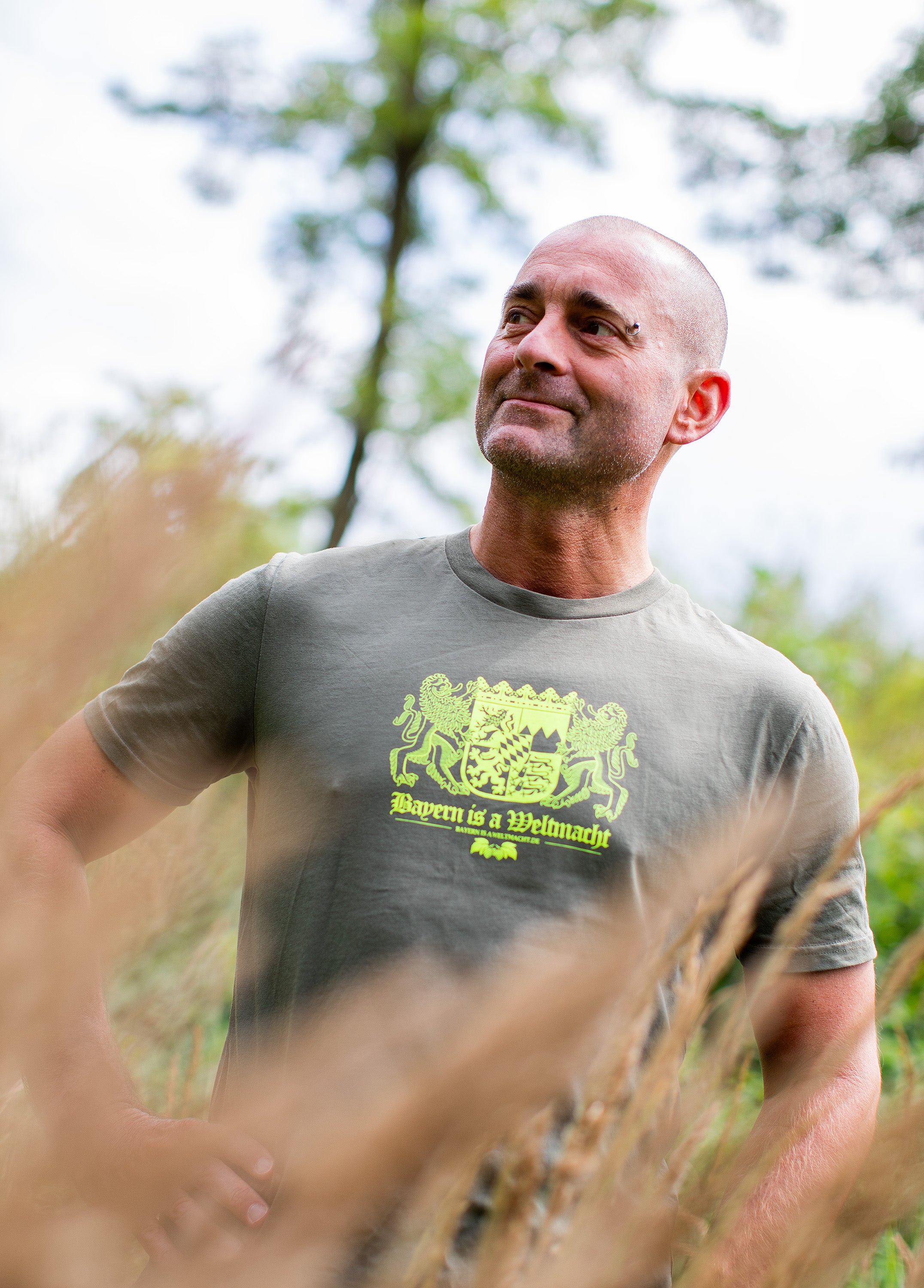 Sepp trägt unser neues Bayern is a Weltmacht T-Shirt im Wald